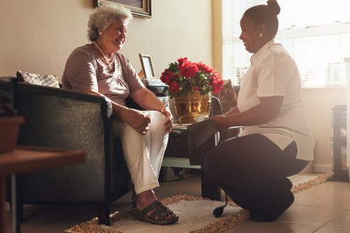 A care worker supporting an older woman at home