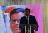 Marimouttou Coumarassamy, speaking at a lectern at BINA's annual conference in Leicester