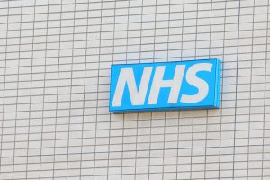 Sign bearing the NHS logo on a building