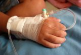 A close up of the hand of a child receiving treatment in hospital